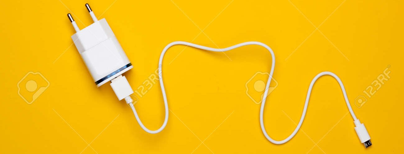 173277655-charger-with-cable-on-yellow-background-top-view